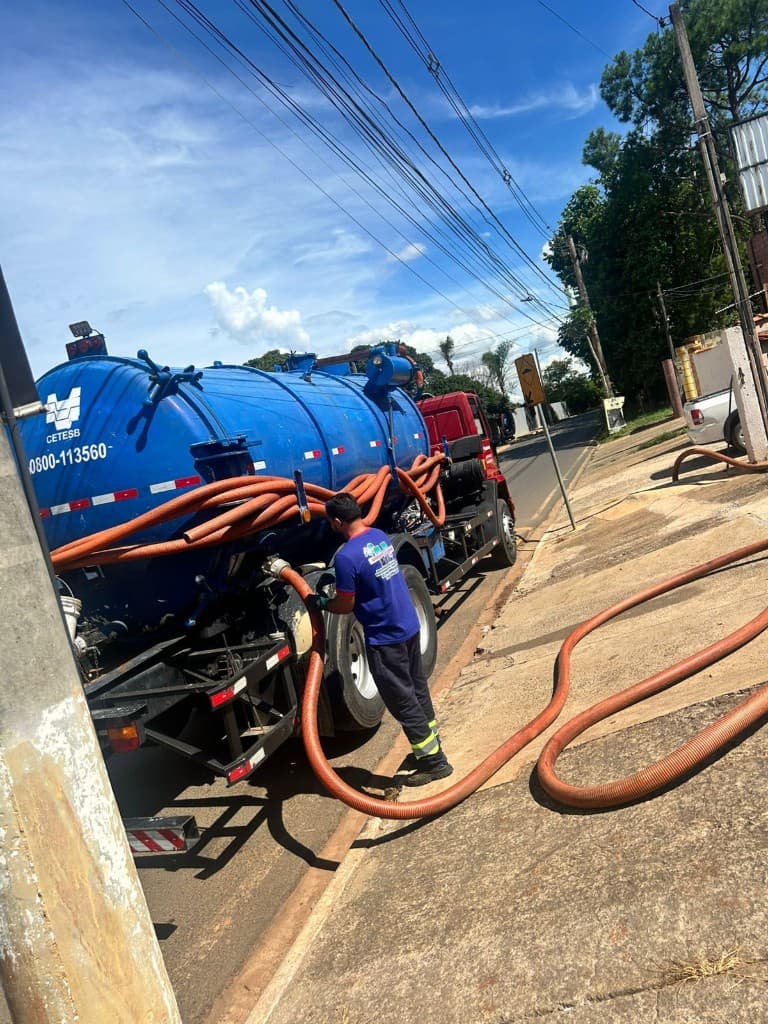 Equipe em campo com mangueiras; caminhão tanque com identificação CETESB