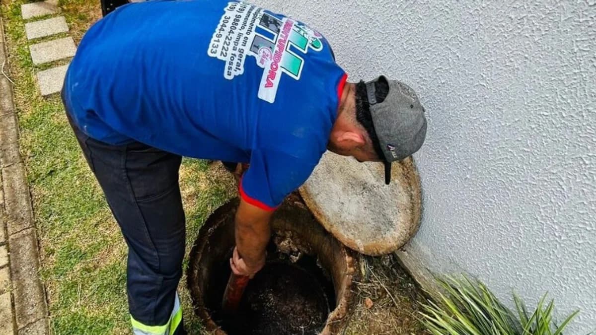 Técnico em campo atendendo desentupimento em boca de lobo junto à edificação